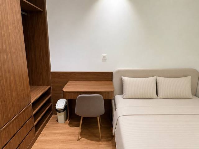 A desk and a wardrobe beside the bed